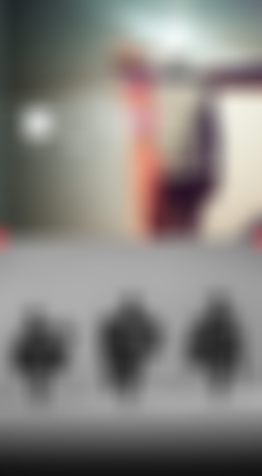 Kiteboarders walking on a misty beach with kite gear, wearing hooded rashguards; a graphic with UV protection info overlays the scene.