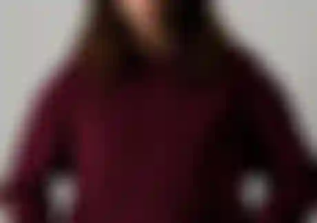 Woman wearing a dark red hoodie with ION logo and a light yellow fisherman beanie