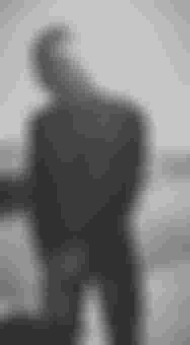 Lasse Walker wearing a kite impact vest and walking on the beach