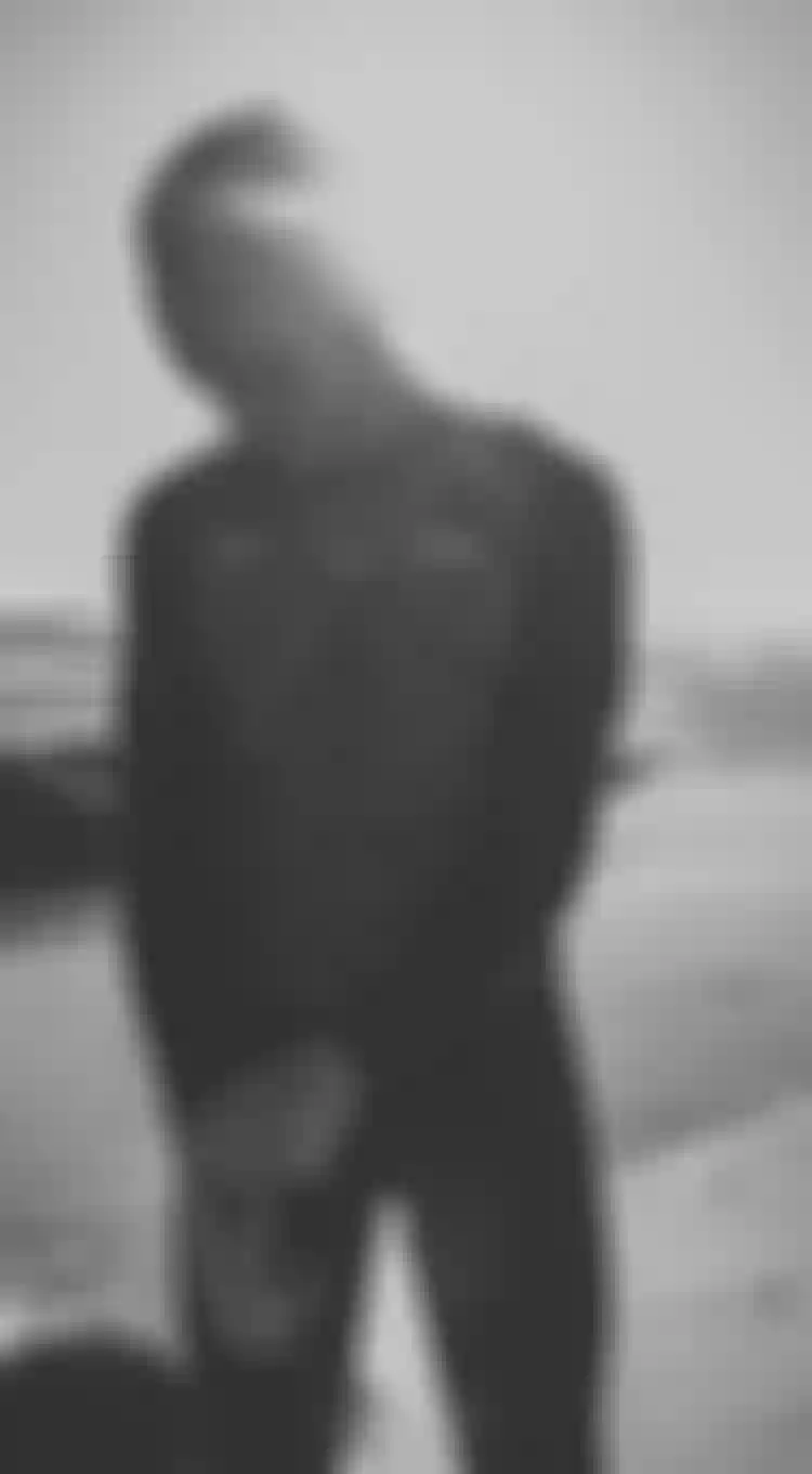 Lasse Walker wearing a kite impact vest and walking on the beach