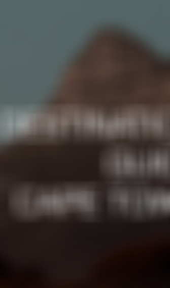 Mountain peak under a cloudy sky with the text "Destination Guide Cape Town" in the center.