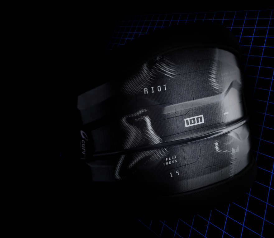 A glossy black ION "RIOT" harness with visible flex index details, set against a dark grid-patterned background.