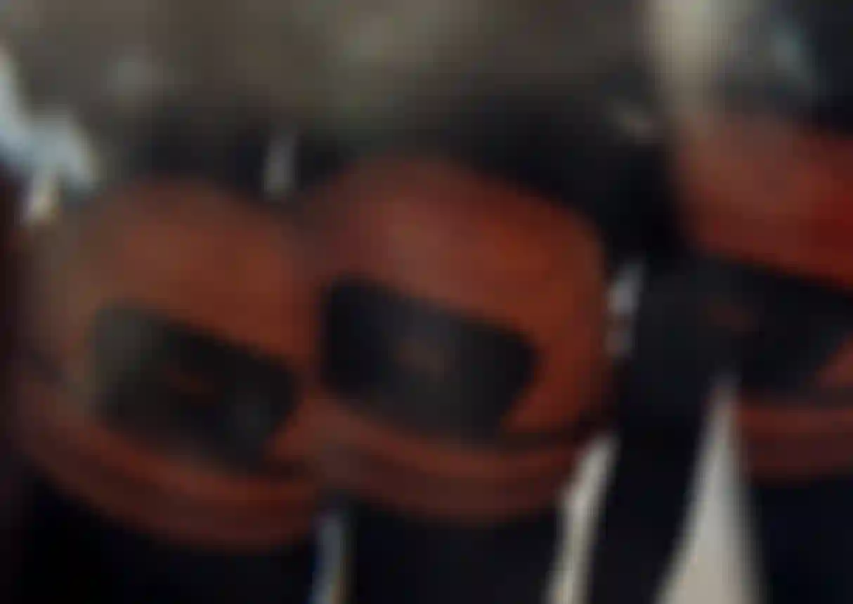 Three people wearing orange ION Muse waist harnesses and black wetsuits, with a blurred effect.