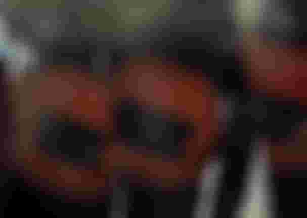 Three people wearing orange ION Muse waist harnesses and black wetsuits, with a blurred effect.