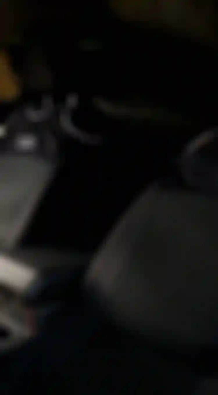 Interior of a vehicle with two black car seats fitted with stylish seat covers, a center console, and a view of the scenery through the window.