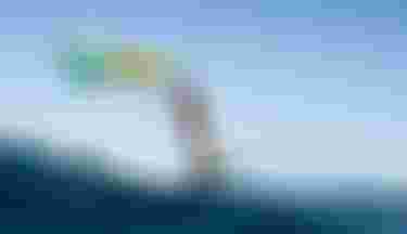 ION athlete Mo Chauvin winging over turquoise water in Guadeloupe, wearing an ION Amaze V-Back wetsuit.