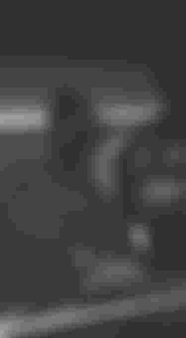 Three men leaning against a car photographed through the windshield