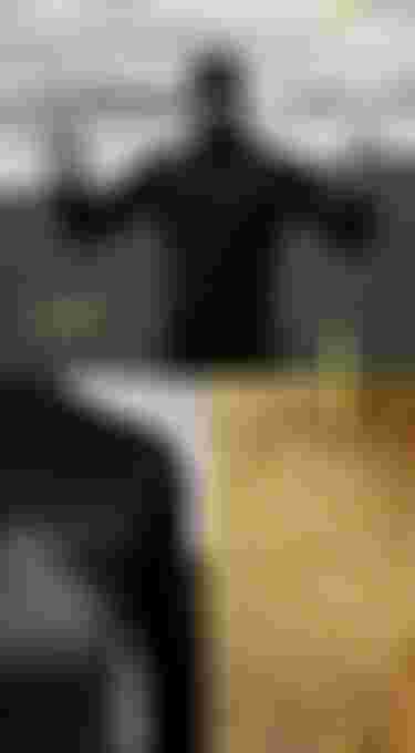 Edgar Ulrich in the rain wearing a black hooded wetsuit, close up of the recycled graphene insulation