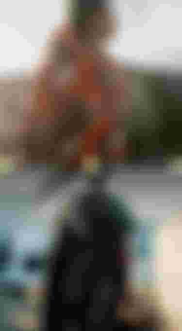 Two people facing the ocean in hooded outfits, with one wearing a red patterned surf poncho. Text reads "Spring/Summer 2026."