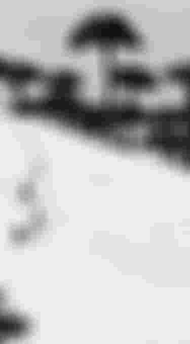 A lone biker carving a single sweeping line through an untouched snowy landscape, seen from above in a minimalistic aerial view.