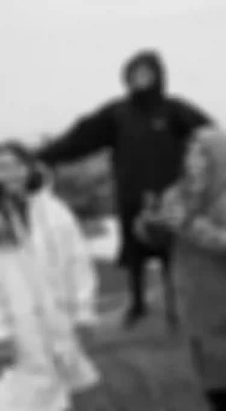 Three people standing on rocks wearing hooded coats