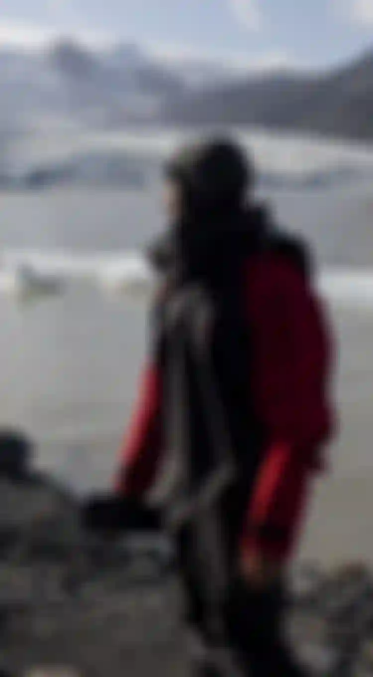 Man in a drysuit in front of a glacier in iceland