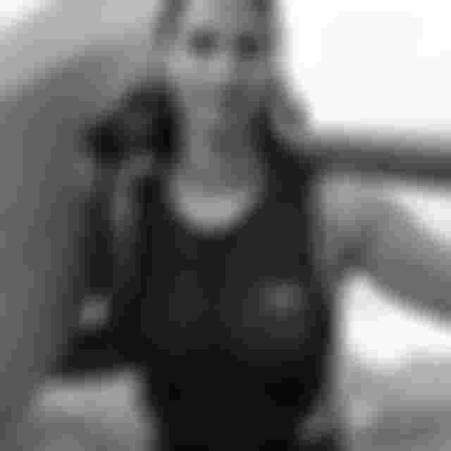 Portrait of athlete Mo Chauvin, wearing an ION wetsuit with a foilboard on her back.