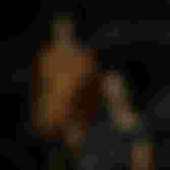 Two women in summer wetsuits on a beach