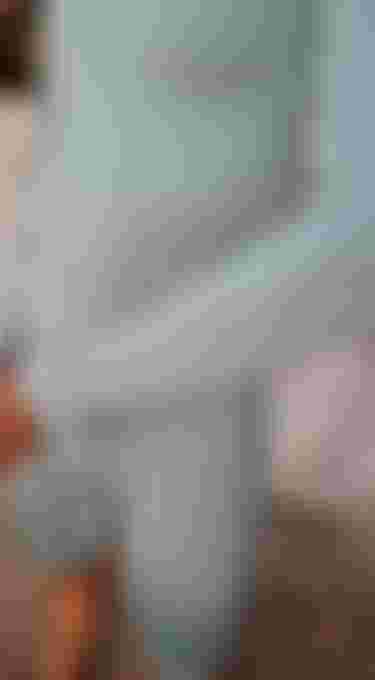close up view of someone wearing a light green shorty wetsuit with long sleeves