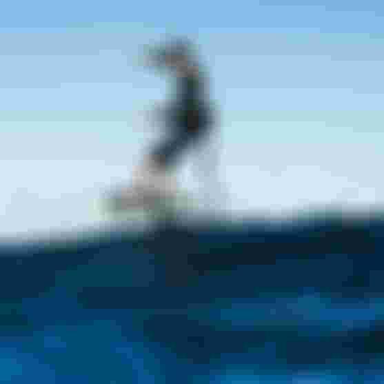 Ion International athlete Leo Etienne riding a wave on a prone foil in Guadeloupe, wearing Ion Surf Shield products.