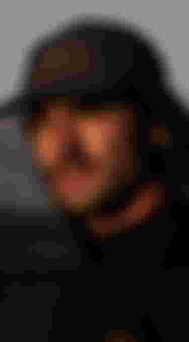 man with hat staring at the setting sun