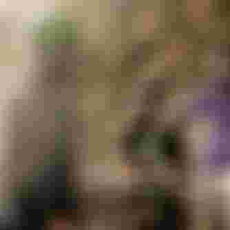 Three mountain bikers in protective gear stand with their bikes on a rugged, sunlit trail, ready for an adventure.