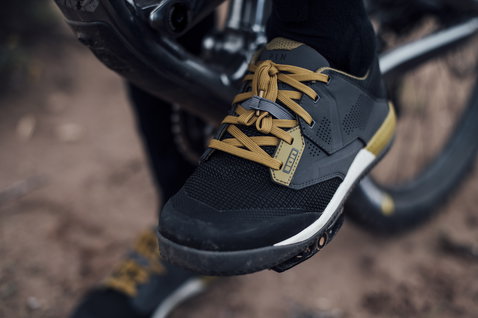 Chaussure vélo ION Scrub Amp pédale plate en noir et kaki lors d'une sortie VTT en forêt