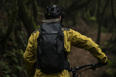 ION Scrub 14 backpack in black during mountain biking in the forest
