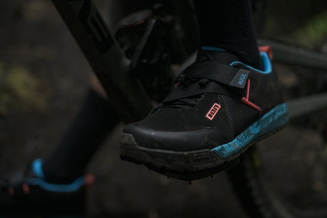 Chaussure VTT ION Bike Rascal en noir et cyan lors d'une sortie vélo de montagne en forêt