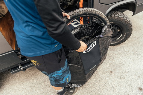 ION Universal Wheel Bag en noir lors du chargement d'une roue de vélo de montagne