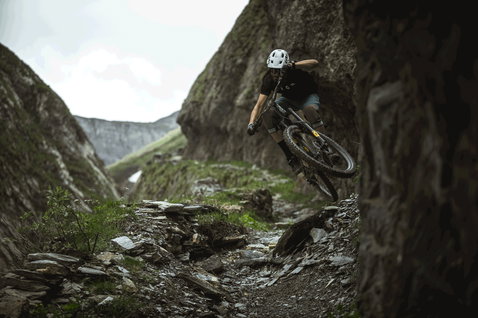 ION Scrub 2.0 Radtrikot in schwarz beim Mountainbiken auf einem alpinen Felsweg