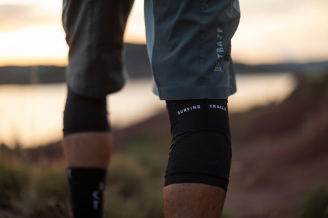 ION K-Sleeve Amp knee pads in black during mountain biking on a trail at golden hour