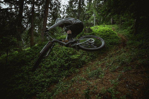 ION K-Pact knee pads during mountain biking on a steep forest trail