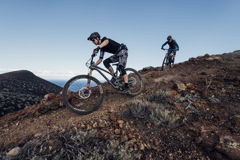 Sac banane ION Bike Traze Plus 3 en noir lors d'une sortie VTT sur terrain volcanique