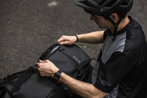 ION Scrub 14 backpack in black during mountain biking on asphalt