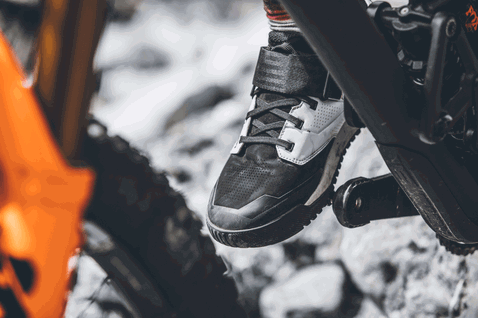 ION Rascal Amp clipless MTB bike shoe in black and light grey during mountain biking on rocky trail