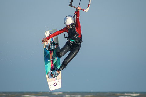 ION Capture 4/3mm back-zip fullsuit in black and teal during kitesurfing
