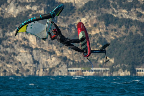 ION Fuse Drysuit 4/3mm back-zip fullsuit in dark teal during wing foiling on a mountain lake