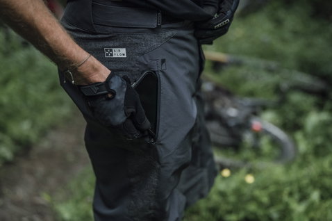 ION Bike Traze Amp AFT Cycling Shorts in schwarz beim Mountainbiken im Wald