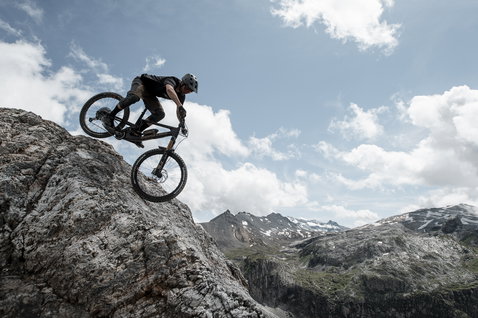 ION Scrub Amp SS Cycling-Jersey in schwarz beim Enduro Mountainbiking in alpiner Berglandschaft