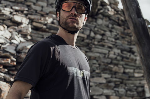 ION Scrub Amp Kurzarm-Bikejacke in schwarz und grau beim Mountainbiken im Gebirge