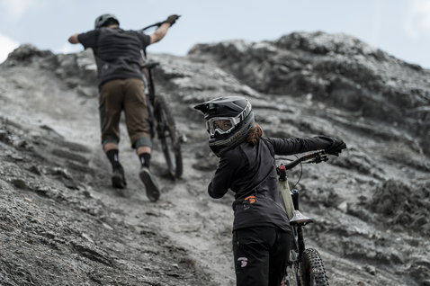ION Scrub Amp LS women cycling jersey in black during enduro mountain biking on rocky trail