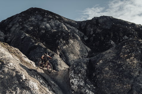 ION Scrub SS women cycling jersey in black during mountain biking on rocky mountain terrain