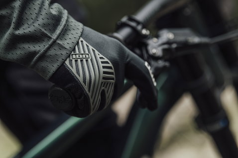 Gants vélo ION Scrub Select en noir lors du vélo de montagne sur le guidon