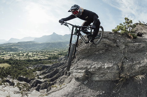 ION Logo Fahrradhandschuhe in schwarz beim Mountainbiken auf felsigem Berggelände