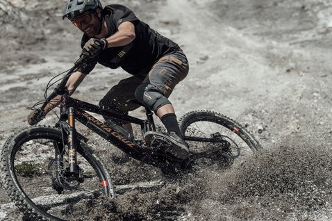 Guanti da ciclismo ION Logo durante il mountain bike su un sentiero enduro polveroso