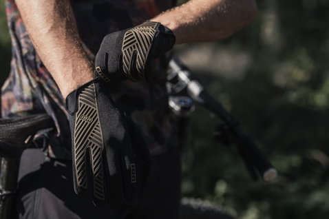 Gants vélo ION Scrub Select en noir et olive lors d'une sortie VTT en forêt
