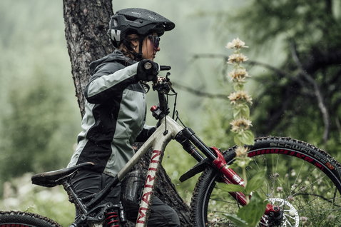 Casque VTT ION Bike Traze Amp MIPS en gris anthracite pendant une sortie trail en forêt