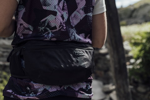 ION Traze hipbag 1 litre in black during mountain biking on a trail
