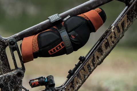 ION Fix Strap L Fahrradgurt in schwarz-grau mit Knieschonern am Mountainbike-Rahmen befestigt