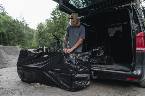 ION Universal Bike Bag in black during mountain bike loading at a van on a trail