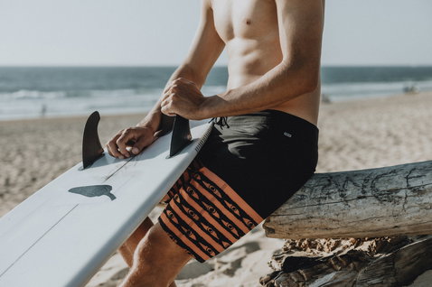 ION Slade boardshorts 19" homme au surf sur la plage en noir et orange