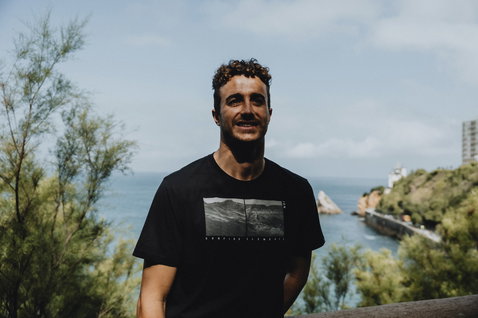 ION Bike Vibes Kurzarm-T-Shirt Herren in schwarz mit Chest-Print beim Tragen an der Küste