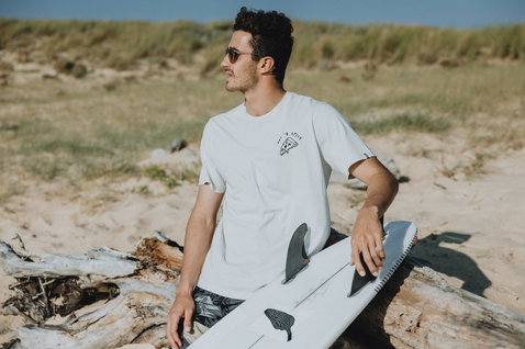 ION Mood T-Shirt Herren beim Beach-Lifestyle am Sandstrand in off-white mit besticktem Brust-Grafik